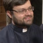 Pe. Luís César de Oliveira sorrindo, de batina e crucifixo