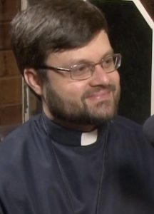 Pe. Luís César de Oliveira sorrindo, de batina e crucifixo